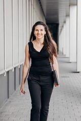 portrait of am attractive business woman, caring a laptop