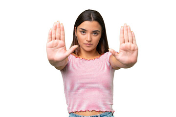 Young caucasian woman isolated on green chroma background making stop gesture and disappointed