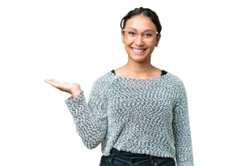 Young Uruguayan woman over isolated chroma key background holding copyspace imaginary on the palm to insert an ad