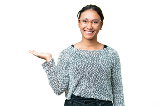 Young Uruguayan woman over isolated chroma key background holding copyspace imaginary on the palm to insert an ad