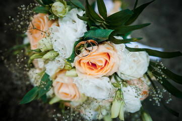 Elegant Wedding Bouquet with Rings and Soft Peach Roses