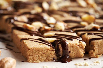 Homemade chocolate bars made of whey protein powder, ground oat flakes, maple syrup, cinnamon and nut butter, close up