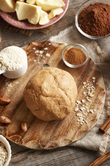Ball of raw dough made of whey protein powder, ground oat flakes, maple syrup, cinnamon and nut butter - preparation of homemade protein bars