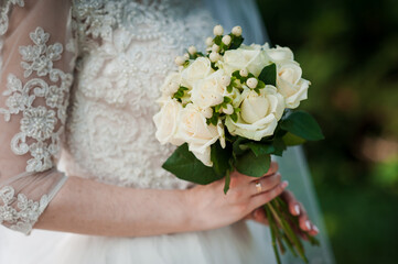 Elegant Bride Holding a Beautiful Bouquet of White Roses