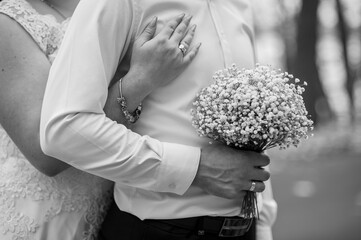 Romantic Black and White Close-Up of a Newlywed Couple Embracing with a Bouquet of Baby's Breath