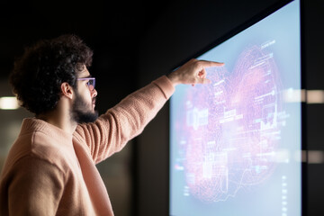 man interacts with digital screen displaying data visualizations, showcasing technology and innovation in modern workspace. His focused expression highlights engagement