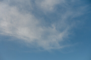 Endless azure sky with wispy clouds drifting lazily on a warm summer day