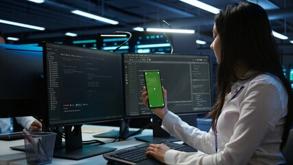 Worker overseeing data center using green screen mobile phone, ensuring system can handle networking tasks. IT expert in server room tracking network traffic with empty copy space smartphone, camera B