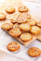Small tarte flambees or pizzas with cheese, onion and bacon made of pretzel dough