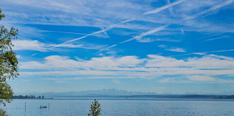 Idyllic view of the lake Constance and Swiss Alps against the backdrop of blue sky with white clouds