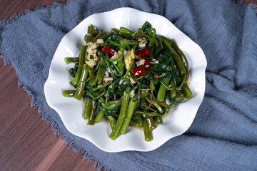 Fried water spinach on a white plate on the table