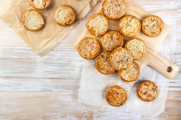 Small tarte flambees or pizzas with cheese, onion and bacon made of pretzel dough
