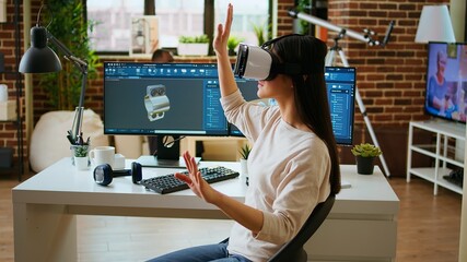 Asian woman engineer creating prototypes with vr glasses and 3D modeling software, working from...