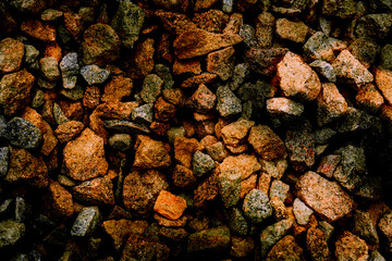 Dark orange red pebbles light stones, gravel, shadows