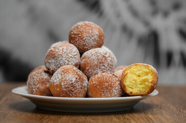 Mini pączki z cukrem pudrem stos na talerzu