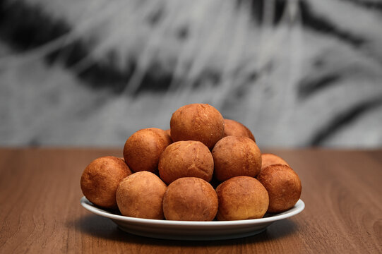 Mini pączki, brązowe okrągłe smażone kulki na talerzu