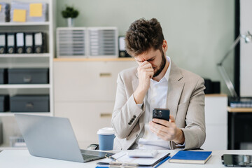 Young stressed caucasian businessman working in the office. Businessman thinking too much work concept in the office.