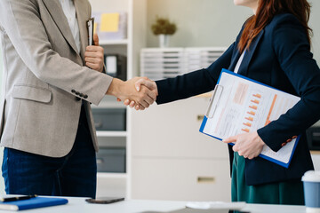 Happy businessman and businesswoman shaking hands at group board meeting. Professional business executive leaders making handshake agreement successful company trade partnership handshake concept.