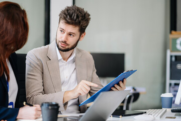 Diverse professionals collaborate on project analysis with financial graphs. Strategic teamwork and...