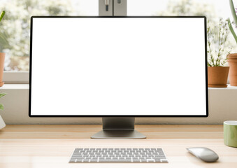 Fototapeta premium All-in-one computer with a blank screen on a transparent background, placed on a wooden desk in a bright interior with potted plants. Front view, close up. CGI 3d render