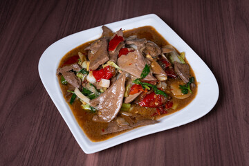 Pork liver with hot and sour pickled peppers on a white plate