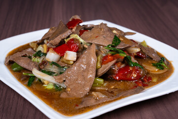Pork liver with hot and sour pickled peppers on a white plate