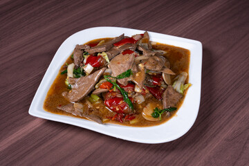 Pork liver with hot and sour pickled peppers on a white plate