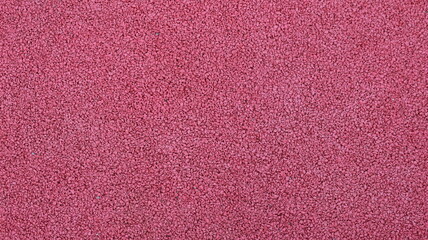 full frame red pink texture, crushed rubber sports surface, reddish grainy soft material, graphic resource and empty textured space