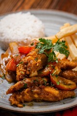 Fried chicken with rice and fries garnished with cilantro.