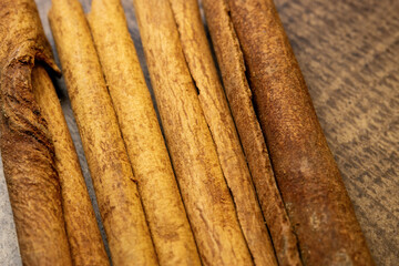 Cinnamon sticks on a wooden background close up.