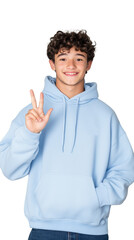 Smiling young man in a light blue hoodie making a peace sign on a transparent background.