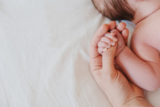 Close-up little hand of child baby holding hand of mother.