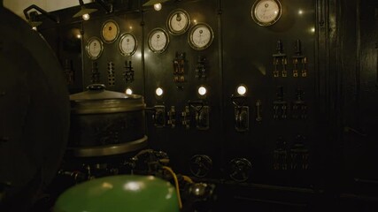 Overview of an old, industrial control panel with a variety of gauges, switches, and dials. Industrial  elements in the interior of Fort de Mutzig fortress, now a museum.