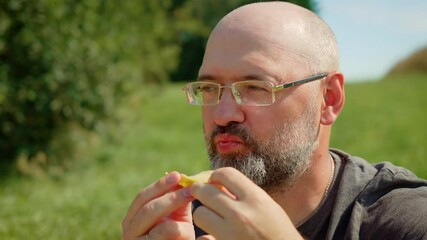 Bearded man eating sour lemon and reacting with puckered face. Male tasting lemon slice and expressing tangy discomfort. Guy trying citrus fruit with amusing facial reaction