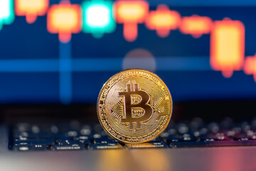 Golden Bitcoin coin on keyboard. Stock market trading chart online candlestick.