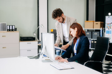 Fototapeta premium Two busy happy professional business man and woman executive leaders team using laptop working