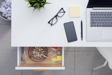 Employee hiding cigarettes in the desk drawer