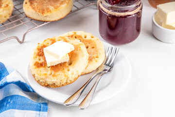 Traditional English skillet fried breakfast pastry Crumpets, popular in England, Britain pancakes. Sweet hot crumpets stack with melting butter and jam