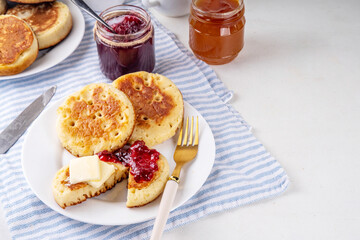 Traditional English skillet fried breakfast pastry Crumpets, popular in England, Britain pancakes. Sweet hot crumpets stack with melting butter and jam