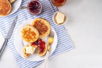 Traditional English skillet fried breakfast pastry Crumpets, popular in England, Britain pancakes. Sweet hot crumpets stack with melting butter and jam
