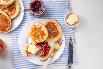 Traditional English skillet fried breakfast pastry Crumpets, popular in England, Britain pancakes. Sweet hot crumpets stack with melting butter and jam