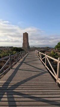 Vertical shot of a walk along the wooden footpath leading to the historic Thieves Tower, dating back to the year 1500, located in the Artola Dunes, Cabopino, Marbella (Malaga, Andalusia, Spain, Europe