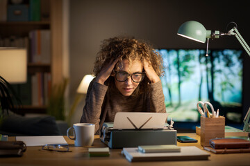 Frustrated writer sitting with head in hands