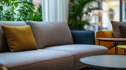 Obraz premium Modern grey sofa with yellow pillow in bright room.