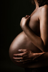 Naklejka premium dad to be holding mum's pregnant belly 