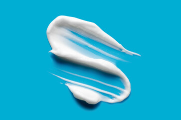 A sample of white cosmetic moisturizer on a blue background