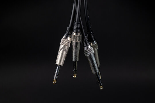 Audio instrument cables hanging on a black background. Concept: Audio, professional audio.