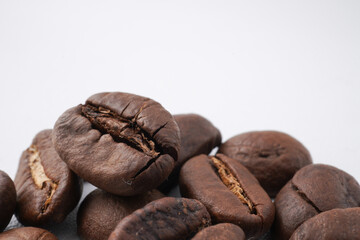 Close up photo of roasted coffee beans and ready to grind. Isolated on white background