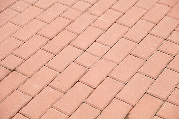 Close-up view of a brick pavement, showing the texture and pattern of the rectangular bricks.  The light peach color of the bricks is uniform.