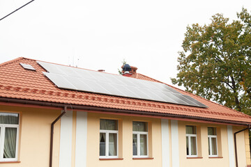 Residential building with solar panels installed on its roof. Sustainable energy solution for home.